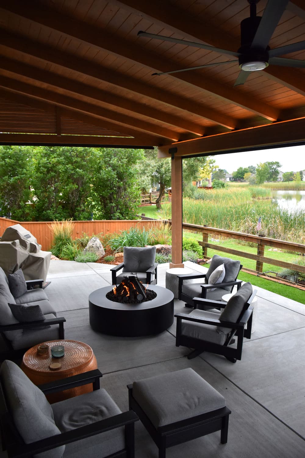 Cozy patio featuring a fire pit, comfortable seating, and lake view in a serene outdoor setting.