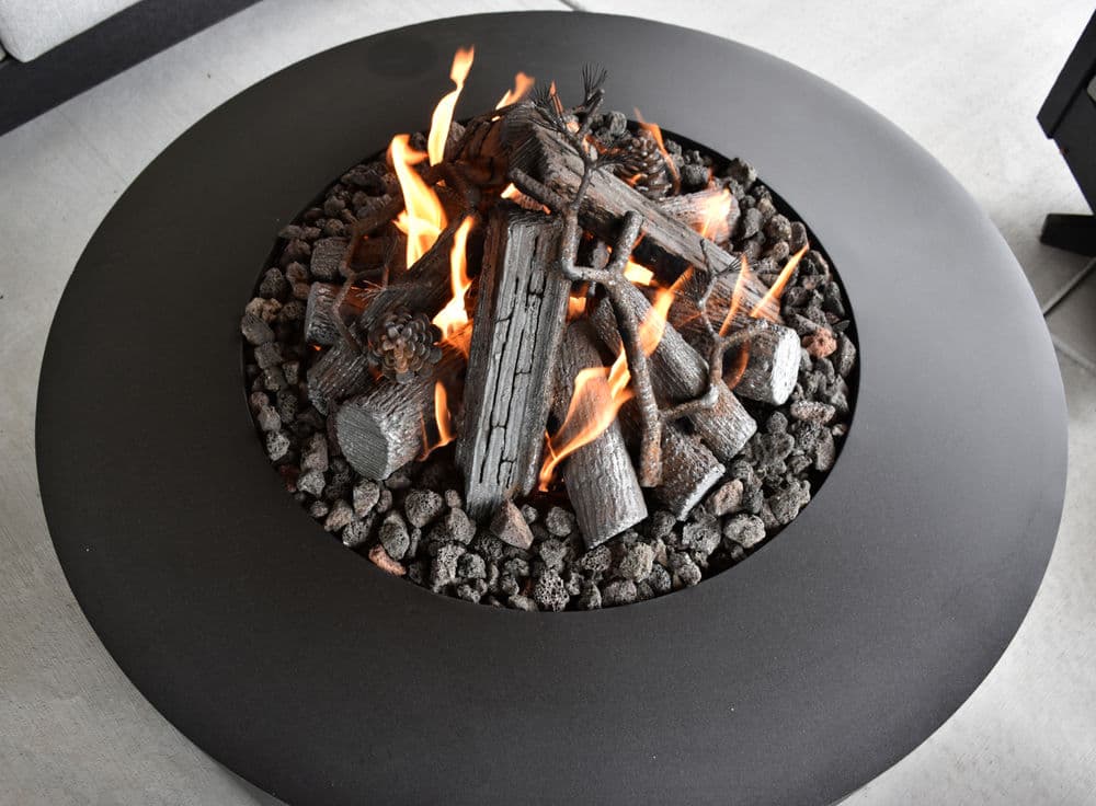 Modern fire pit with burning wood and rocks, perfect for outdoor gatherings and warmth.
